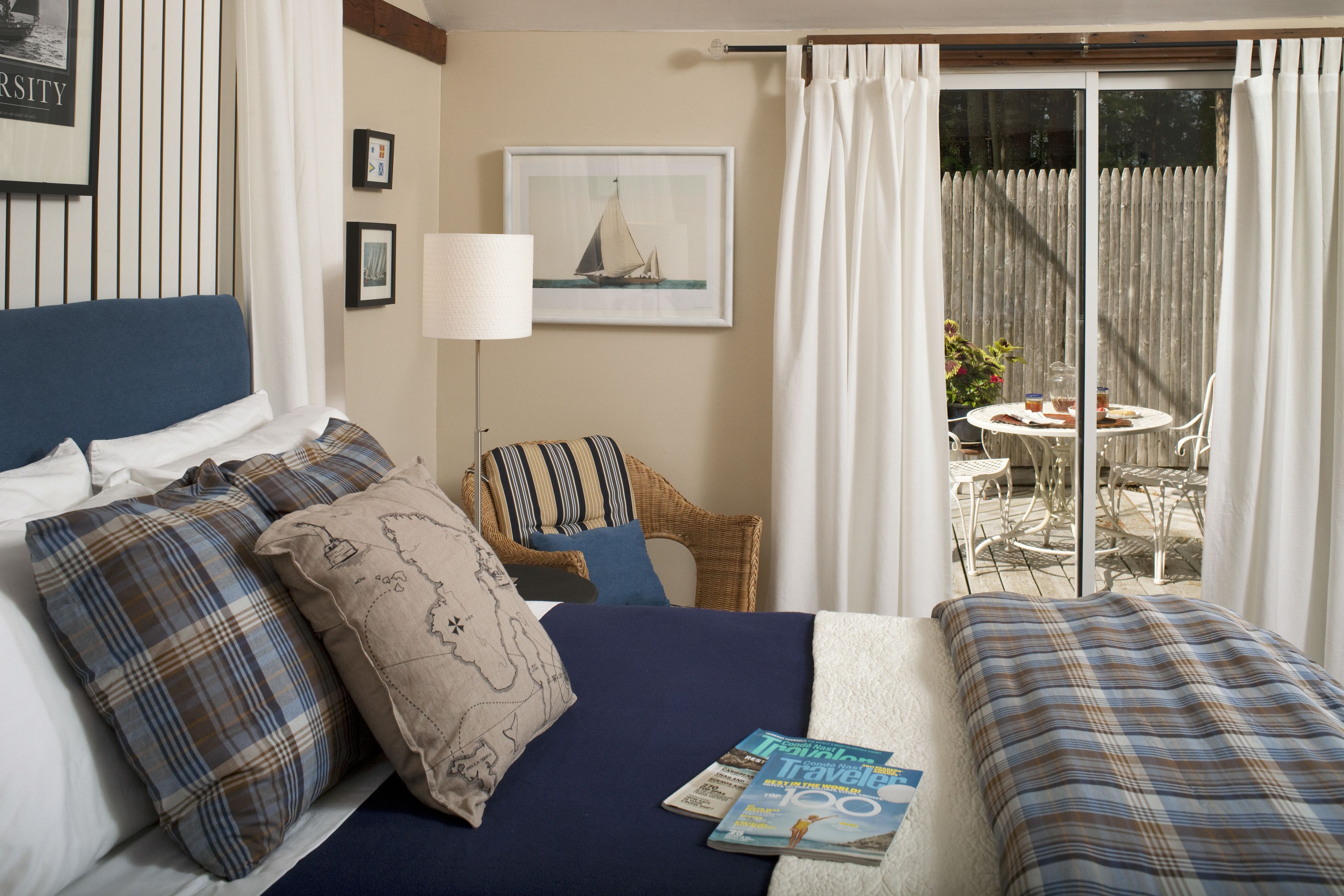 Habitación de hotel con cama, una silla, una mesa y un balcón con vistas.