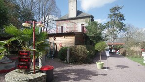 A building with a stone base, a wooden upper structure, and a chimney. There are signs indicating 'Annexe', 'Manoir', and 'Parking'. - Le Domaine de la Belle Normandie (Condé-en-Normandie)