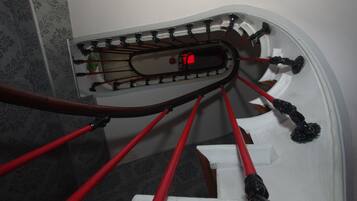 A staircase with red handrails and black balusters.