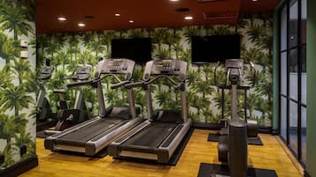 Ein Fitnessstudio mit Laufbändern, Ergometer und Rudergerät.