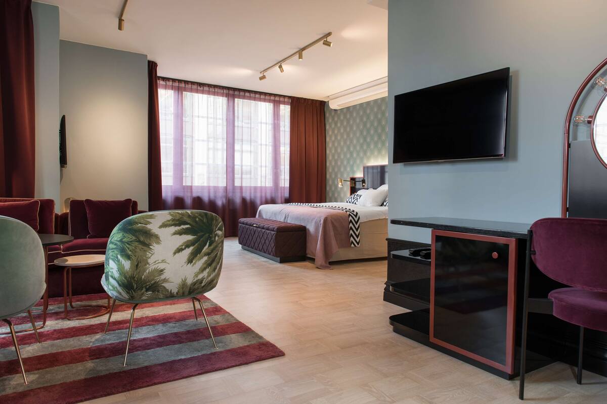 Une chambre d’hôtel moderne équipée d’un lit, d’une télévision, d’un bureau et d’une chaise.