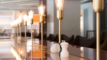 A modern hotel lobby with a long, reflective marble reception desk, elegant light fixtures, and a clean, contemporary design.