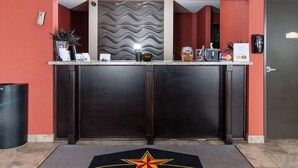 Un mostrador de recepción con el logotipo de Western Star Inn & Suites, una barra de color oscuro y un cubo de basura a la izquierda.