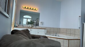 Une salle de bain moderne avec un grand miroir, un meuble-lavabo et une baignoire.