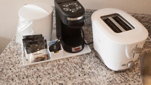 A kitchen counter with a coffee maker, a toaster, and a coffee pod holder. - Western Star All Suites Melita (Melita)