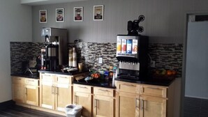 A kitchen with wooden cabinets, a coffee machine, a refrigerator, and a microwave. - Western Star All Suites Melita (Melita)