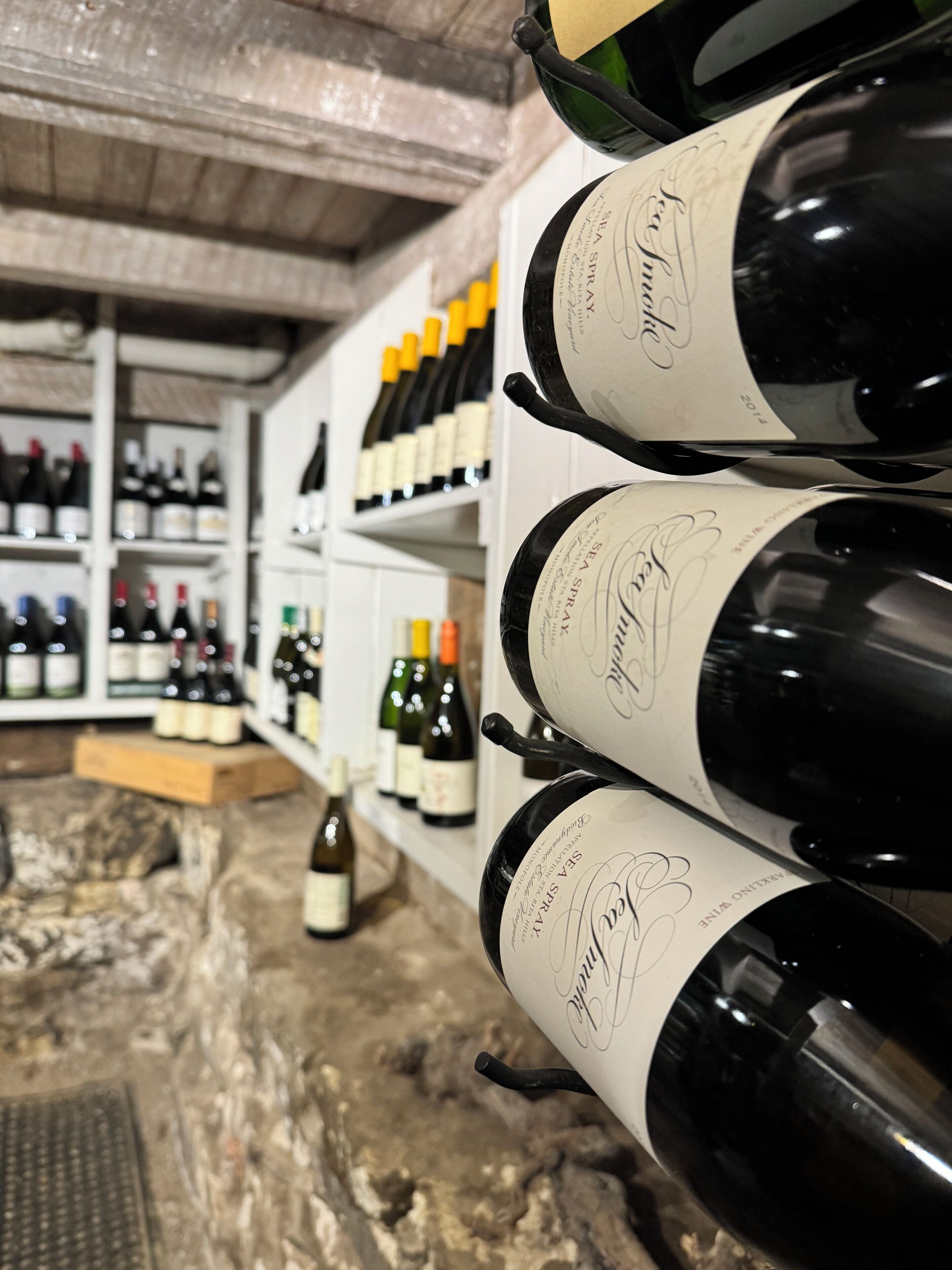 A wine cellar with rows of wine bottles on shelves.