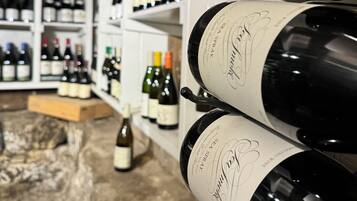 Una bodega con hileras de botellas de vino en estantes.