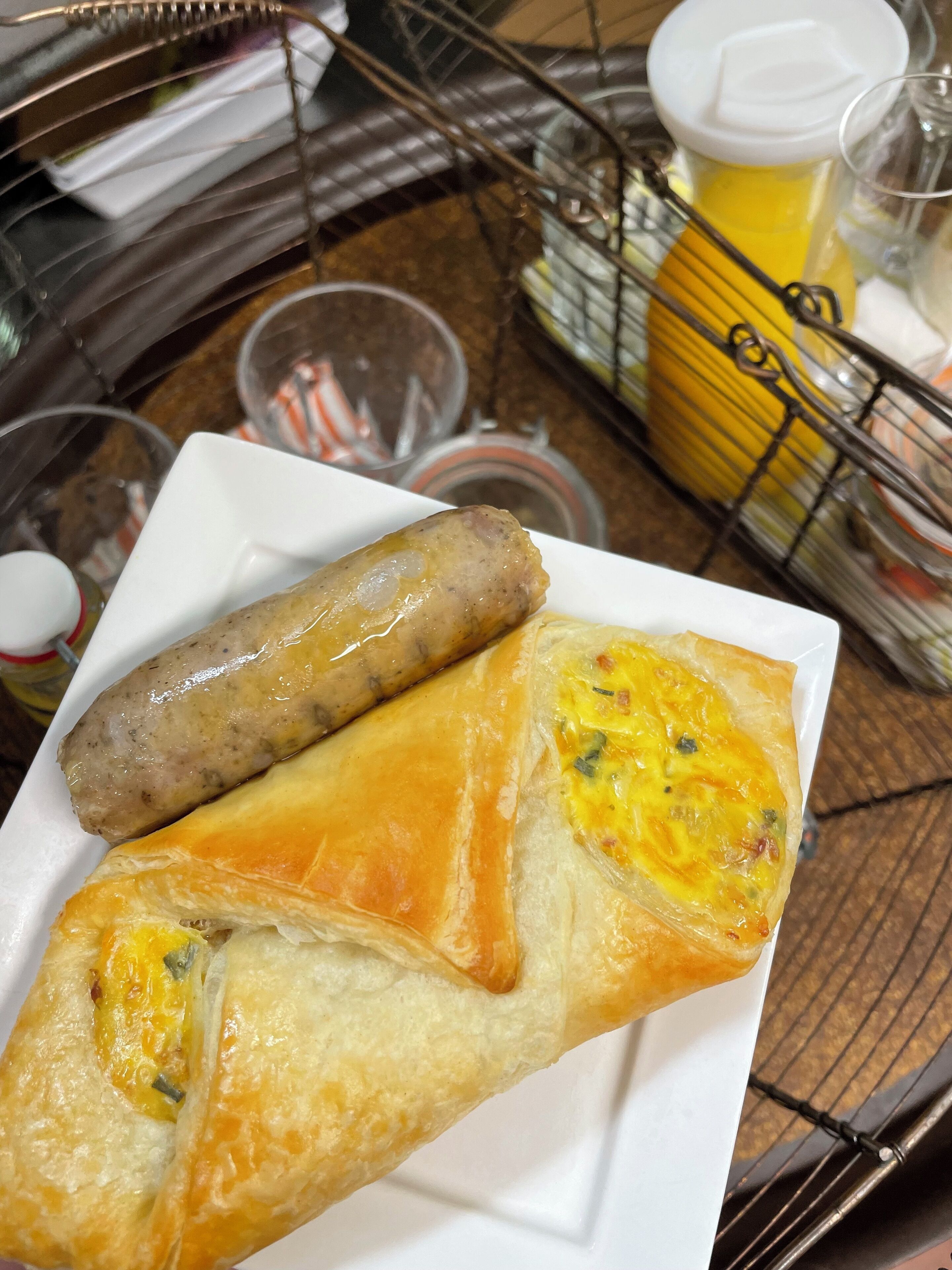 A plate with two sausages and a pastry.