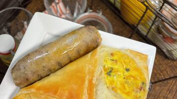 A plate with two sausages and a pastry.
