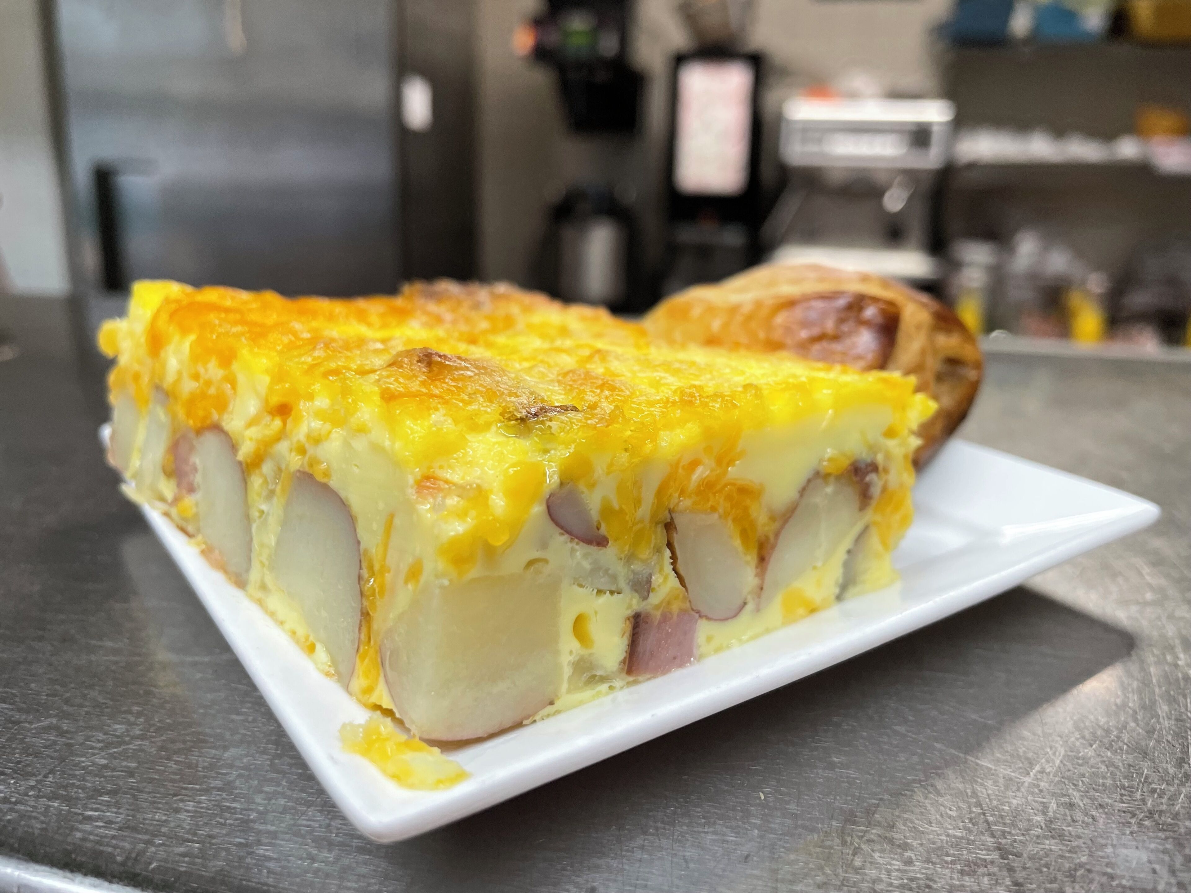 Una porción de quiche sobre un plato blanco.