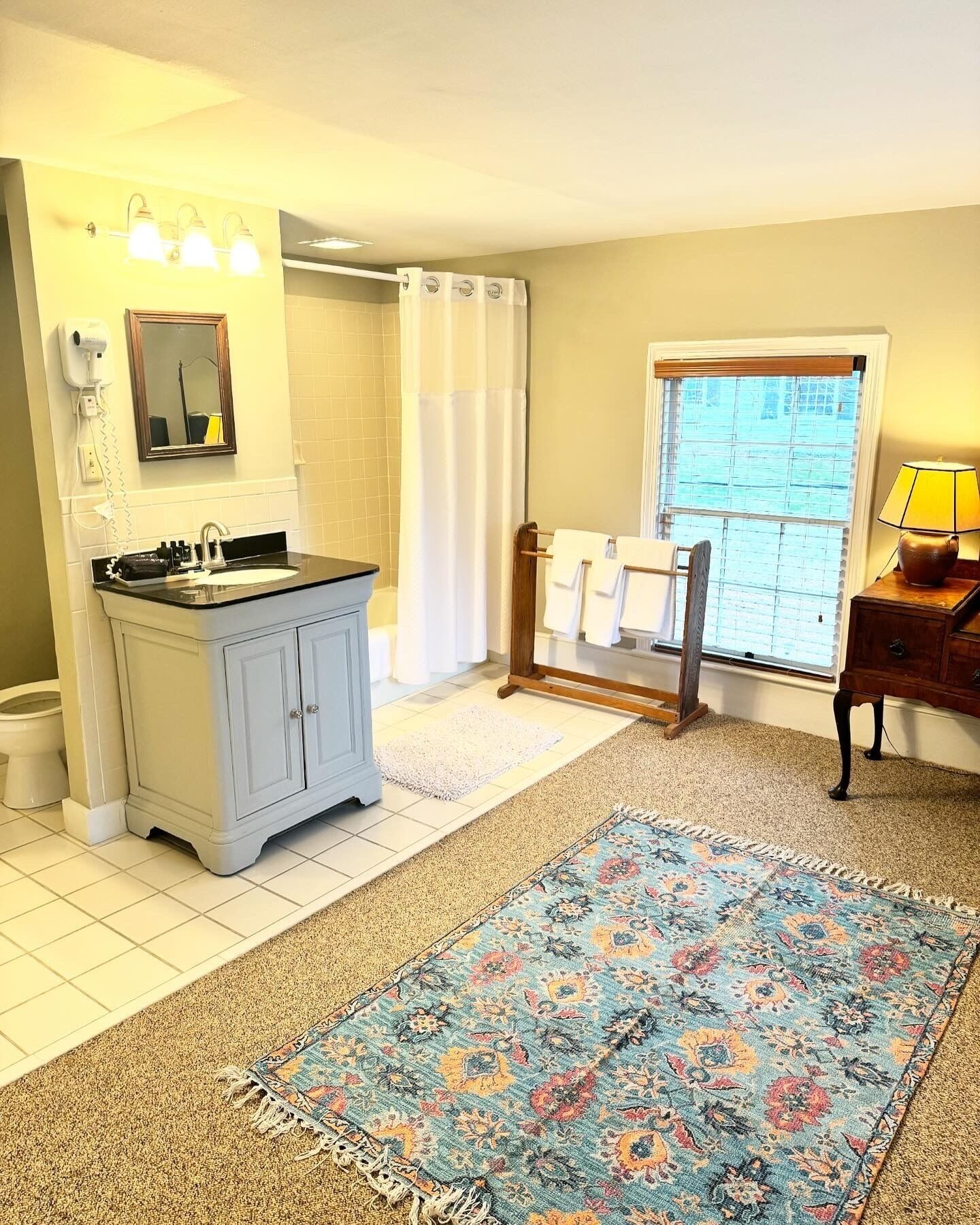 A bathroom with a sink, mirror, and towel rack.