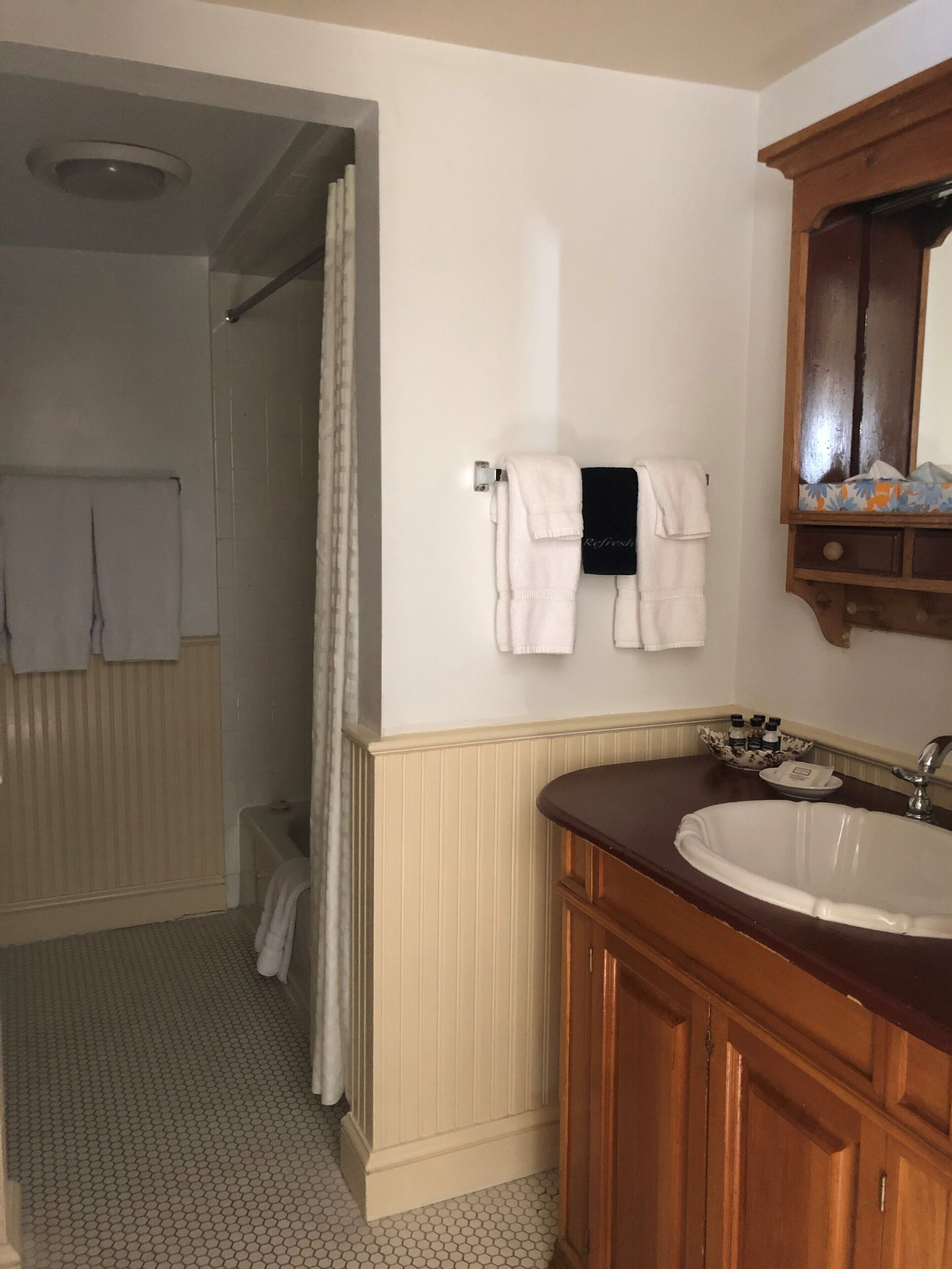 A bathroom with a sink, mirror, and towel rack.