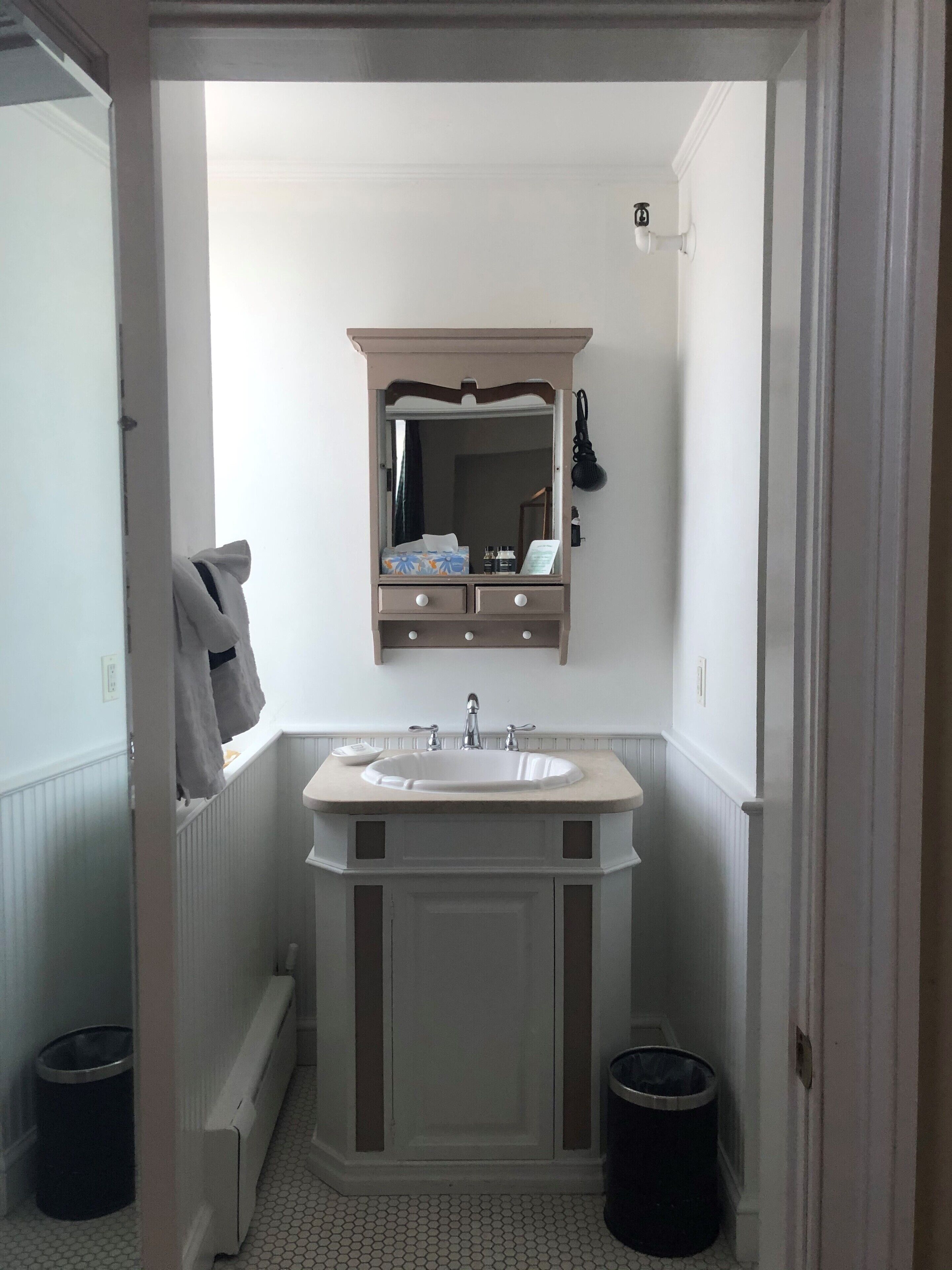 Un bany amb un lavabo doble, mirall amb tocador i dues papereres.