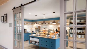 A modern kitchen with blue cabinetry, white subway tiles, and pendant lighting. - Country Inn & Suites by Radisson, Smithfield-Selma, NC (Smithfield)