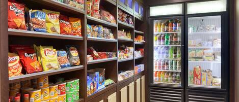A snack and beverage section with shelves stocked with chips, snacks, and a refrigerated display of drinks.