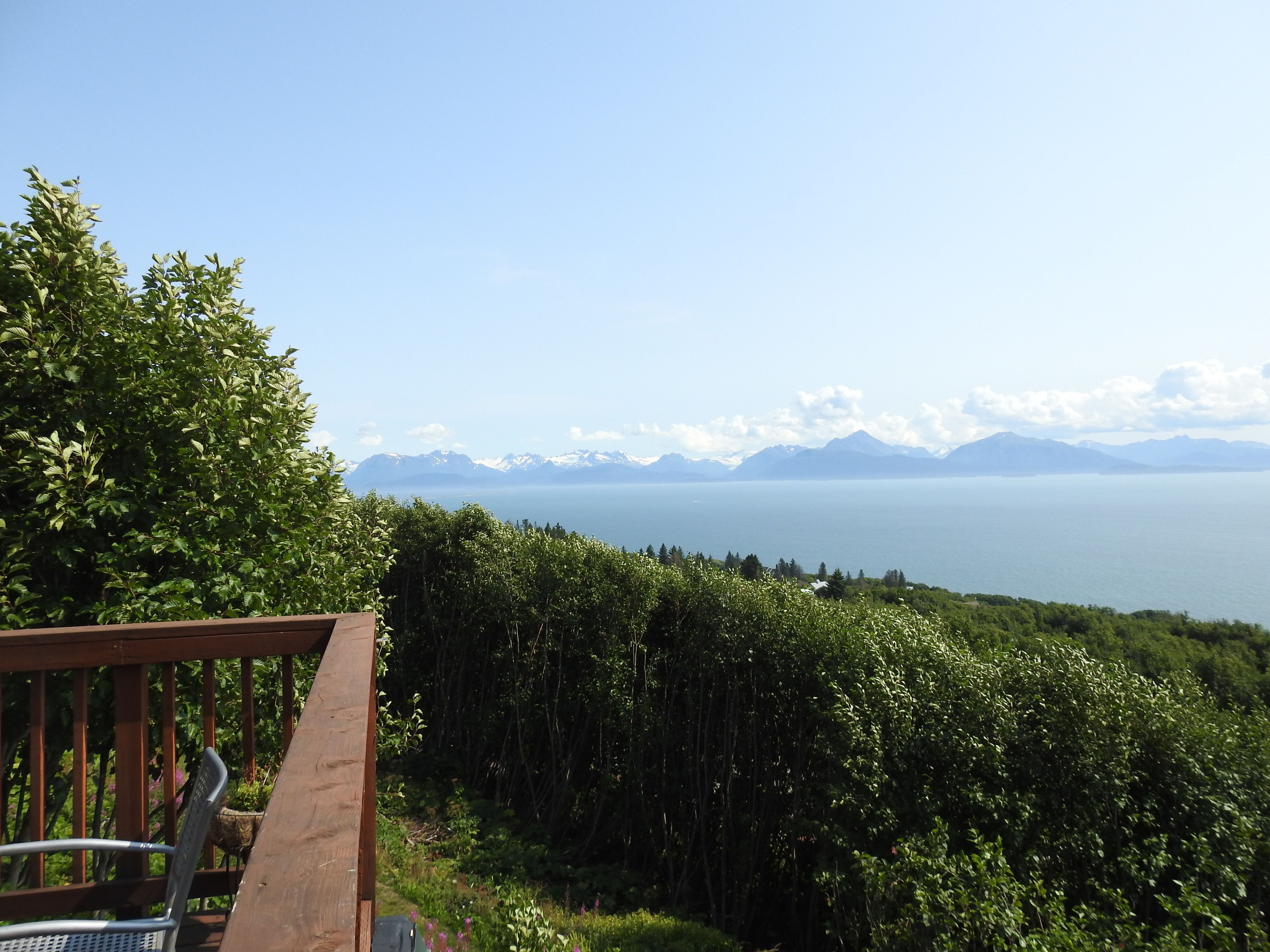 Une terrasse offrant une vue panoramique sur un paysage montagneux et la mer.