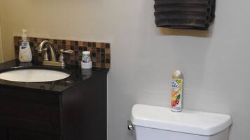 A bathroom with a sink, toilet, and a towel rack.