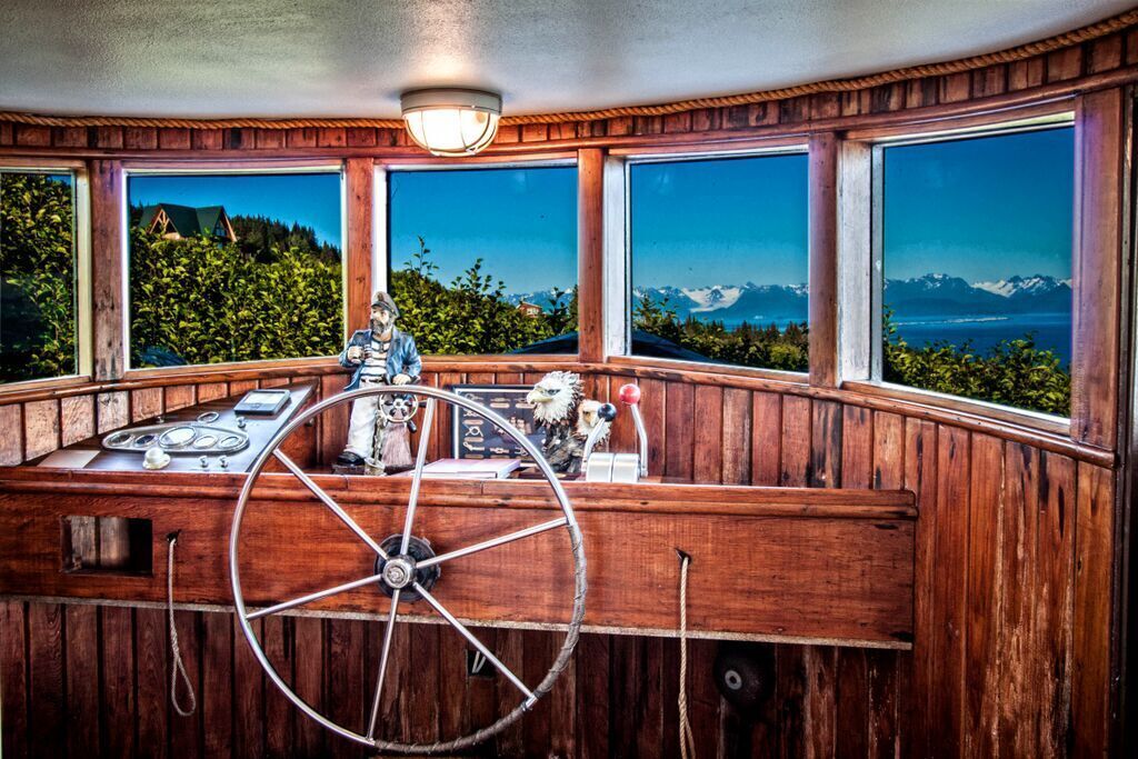 A wooden cabin with large windows offering scenic mountain views.