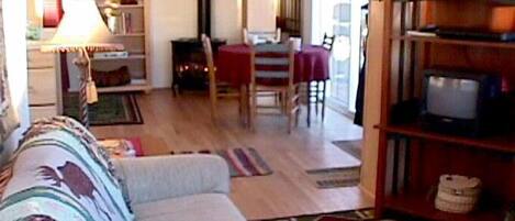 Een woonkamer met een bank, een eettafel en een tv-meubel.