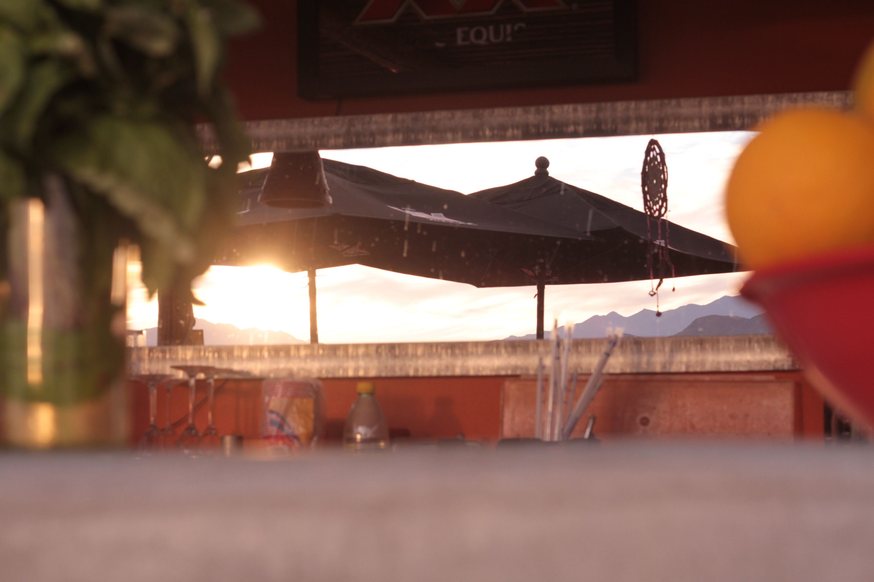 A restaurant with outdoor seating, a mountain view, and a sign that reads "Equi".