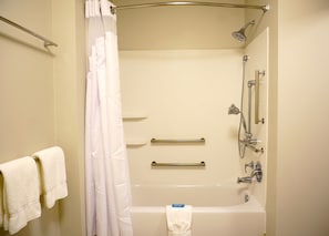 A standard hotel bathroom with a bathtub, shower, and handrails. - Holiday Inn Express & Suites Omaha - Millard Area by IHG (Omaha)