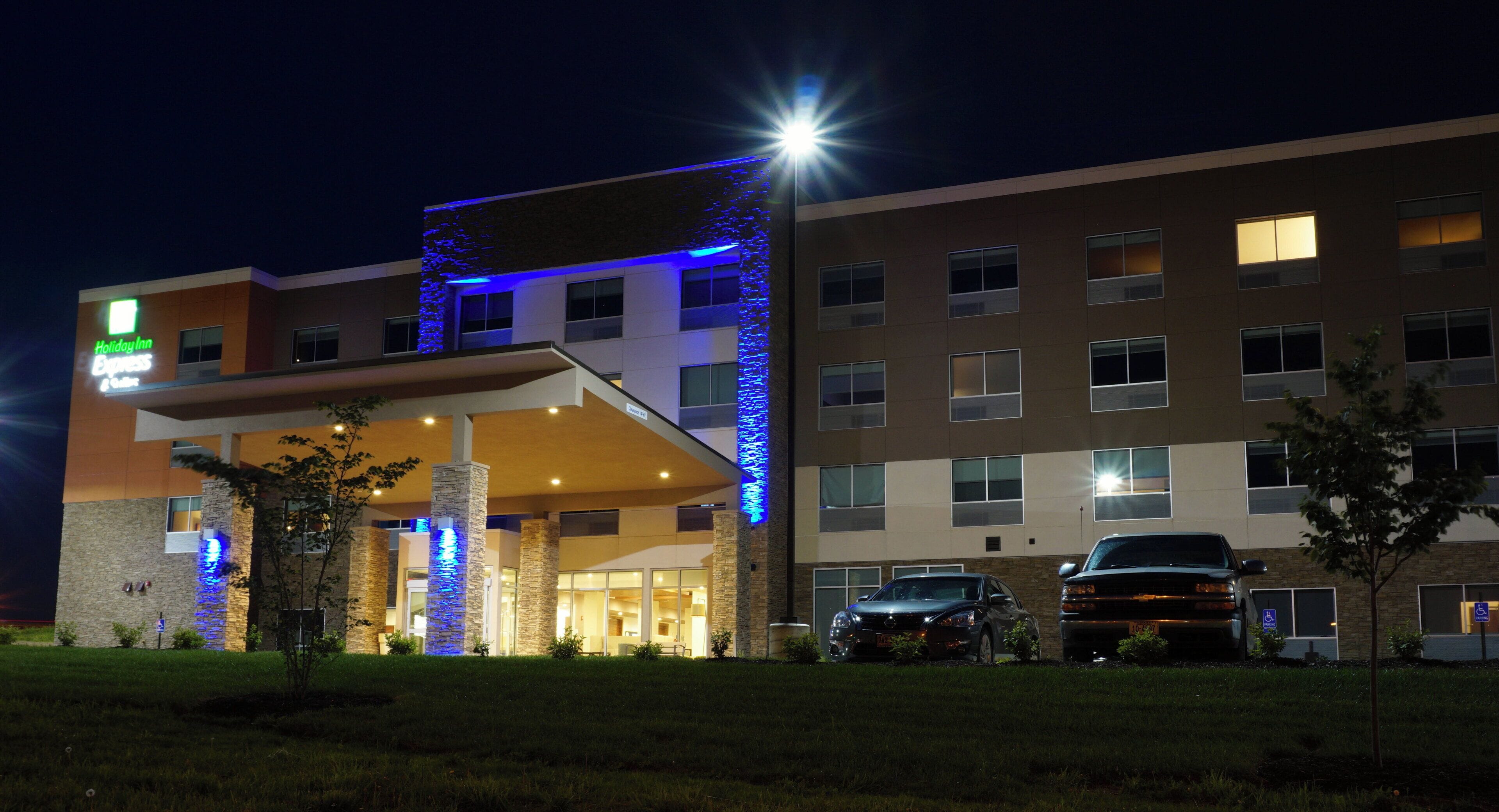 A Holiday Inn Express hotel with a modern design, featuring a prominent entrance and a parking area.