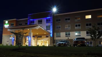A Holiday Inn Express hotel with a modern design, featuring a prominent entrance and a parking area.
