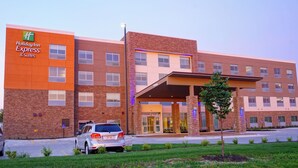 A Holiday Inn Express & Suites hotel with a brick facade, a covered entrance, and a parking lot.