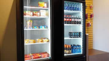 Duas máquinas de venda automática repletas de bebidas e lanches.