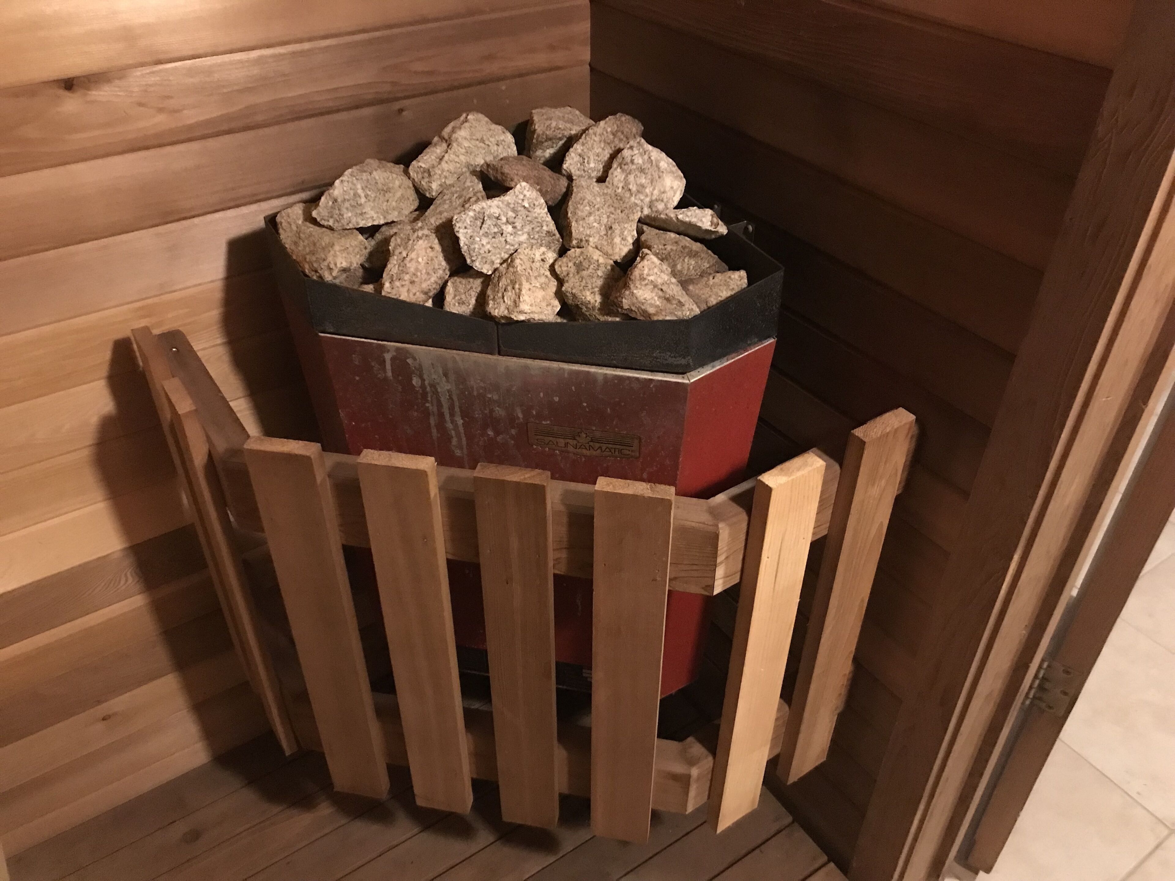 A wooden cabin with a fireplace containing firewood.