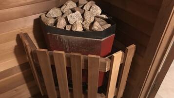 A wooden cabin with a fireplace containing firewood.