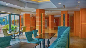 A modern hotel lobby with seating areas, a reception desk, and a view of the outdoors. - Club Aqua Plaza (Alanya)