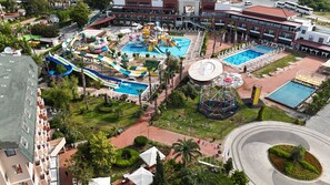 Una vista aerea di un resort con diverse piscine, scivoli acquatici e un carosello.