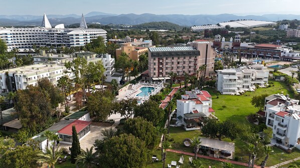 Ein Resort mit Pool, mehreren Gebäuden und einer Bergkulisse.