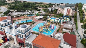 Ett semesterhotell med pool, vattenrutschkanor och utsikt över stranden.