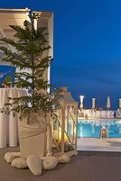 Una piscina al aire libre, sombrillas, sillones reclinables de piscina