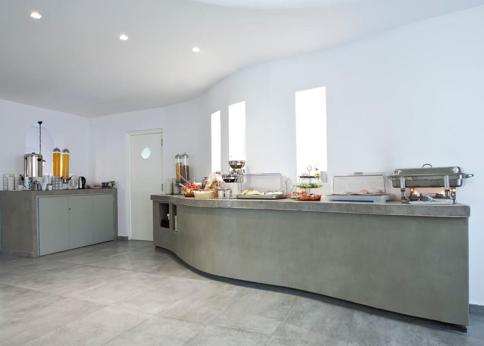 A modern kitchen with a curved island, equipped with various appliances and food items.