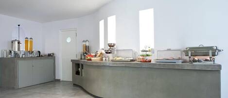 A modern kitchen with a curved island, equipped with various appliances and food items.