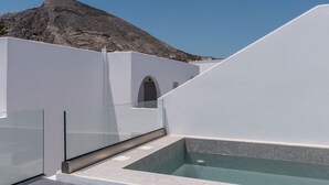 Terraza en la azotea con piscina, dos toallas y una montaña al fondo.