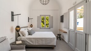 Un dormitorio con cama, mesita de noche, lámpara, ventana y armario.