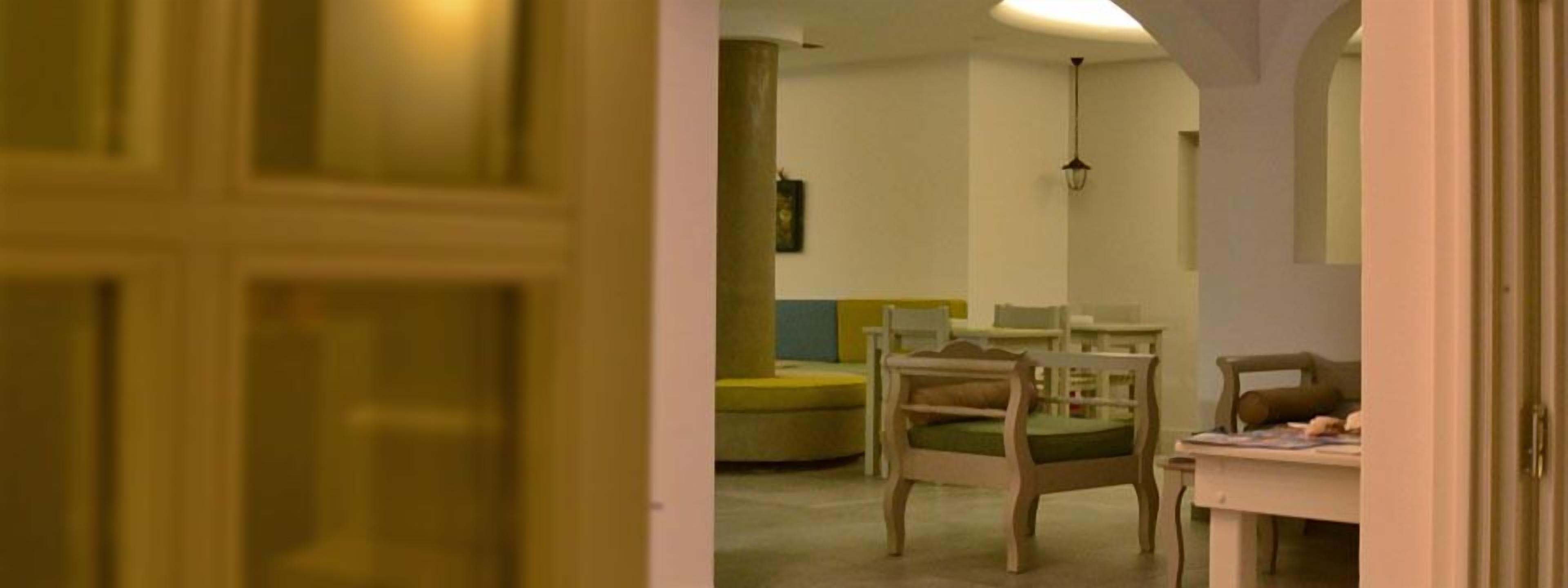 Una habitación con una cama, una silla, una mesa y una lámpara.