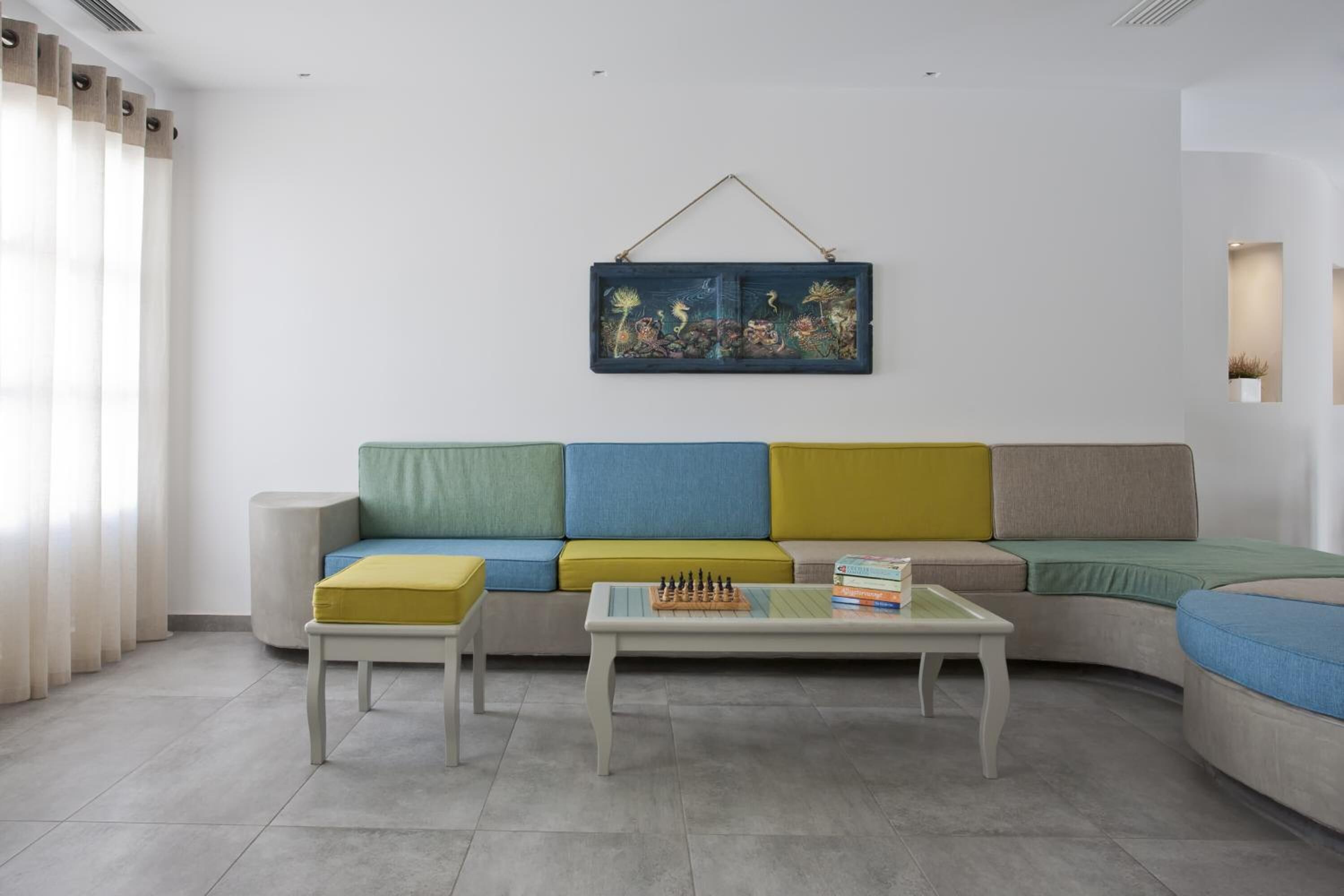 A modern living room with a sectional sofa, a coffee table, and a wall-mounted artwork.