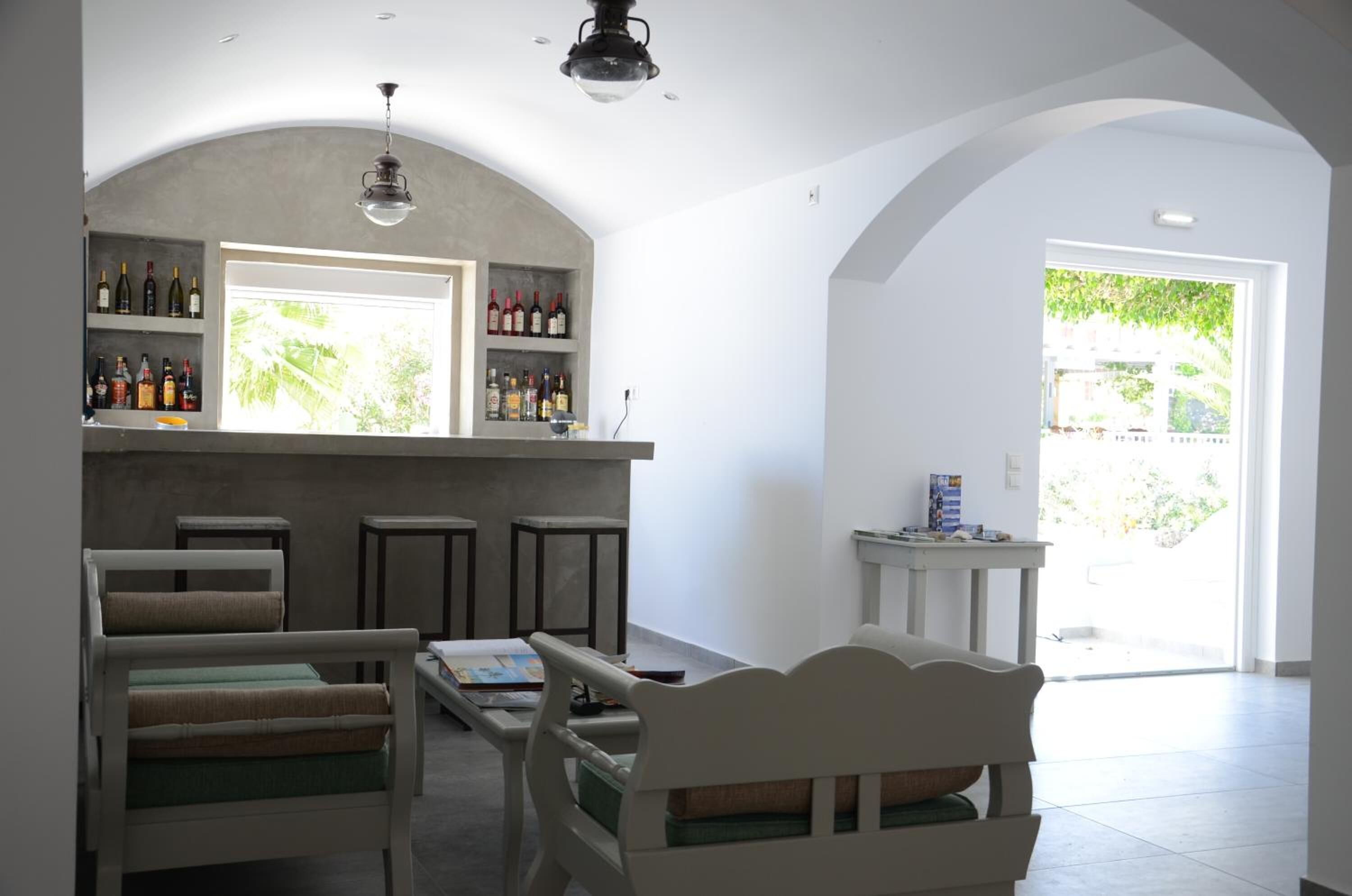 Ein Zimmer mit Bar, Sitzgelegenheiten und Blick auf Grünflächen.