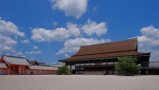 A traditional Japanese building with a large open courtyard, wooden structures, and a clear blue sky. - Sumiya Ryokan (Kyoto)