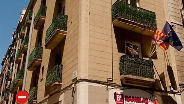 Un edificio a più piani con balconi, una insegna che indica un ostello e un'insegna per il parcheggio.