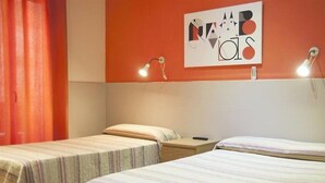 Una stanza con due letti singoli, un quadro appeso al muro e due lampade da comodino.
