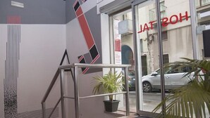 Ingresso di un hotel dal design moderno, con una scala in metallo e una pianta in vaso.