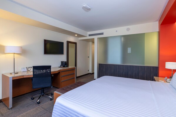 A hotel room with a bed, desk, chair, and a television on the wall. - Holiday Inn Mexico City-plaza Universidad (Mexico City)