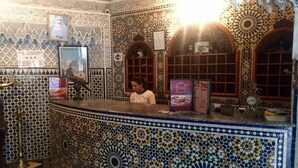 A reception area with intricate tile work and a counter with a menu. - Hotel Al Mamoun (Casablanca)
